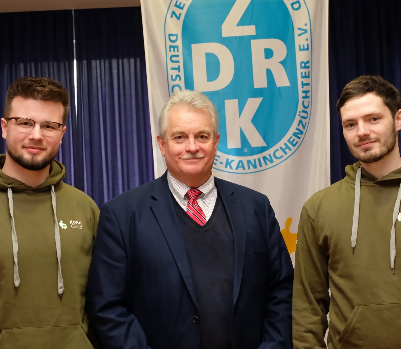 Maurice und Vlady mit einem weiteren Mann vor einem ZDRK-Banner
